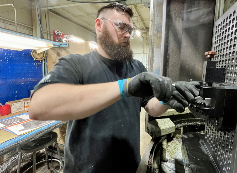 Ryan Walther, an 2023 apprentice at Oxford-based Barron Industries, adjusts machine settings. Peg McNichol/MediaNews Group