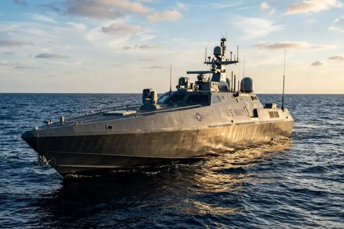 Unmanned surface vehicle marked U.S. Navy operating at sea with mounted sensors and surveillance equipment, representing autonomous naval systems supported by Barron Industries' precision investment cast components.